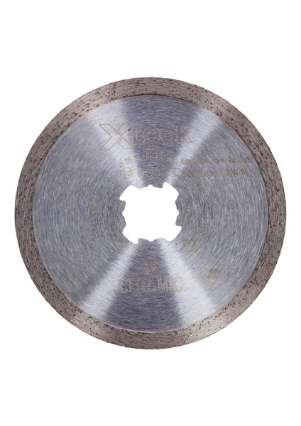 Cirkelformat metallblad med tandad kant och mittöppning, text och märkning synlig.