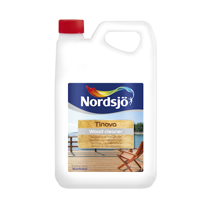 Plastdunk med Tinova Wood Cleaner från Nordsjö, röd kork och etikett med träbeklädd altan och hav i bakgrunden.
