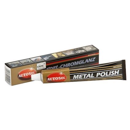 Tandkrämstubsformad metallpoleringsprodukt med texten "AUTOSOL METAL POLISH" bredvid en kartongförpackning.