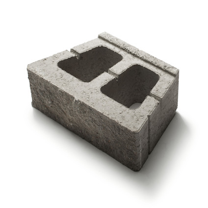Betongmurblock med två stora rektangulära hål, grå yta och skrovlig textur.