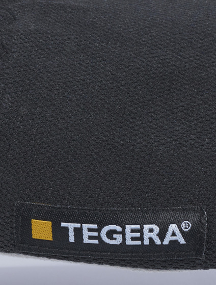 Svart material med litet etikett som har texten "TEGERA" och en gul kvadrat bredvid.