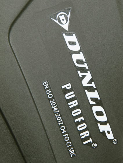 DUNLOP-logotyp och text "PUROFORT" på en grön yta. Text: "EN ISO 20345:2011 S4 FO CI SRC".