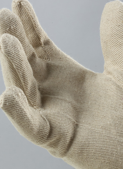 Stickad handske i beige tyg, öppen handflata mot grå bakgrund.
