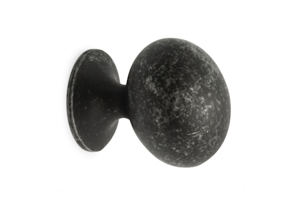 Mörk knopp med rund form och slät yta mot en vit bakgrund.