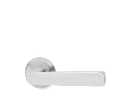 Snyggt dörrhandtag i borstat stål med rund rosett och enkel, stilren design.