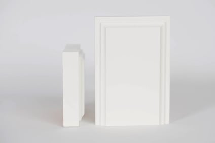 Två vita, rektangulära skivor stående bredvid varandra mot en grå bakgrund.