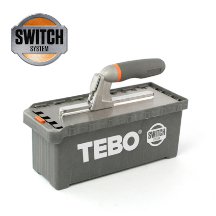 Rektangulär grå plastbehållare med texten "TEBO" och ett handtag ovanpå. "SWITCH SYSTEM"-logga synlig i hörnet.