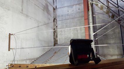 Stort, obearbetat betongrum med spända kablar och metallramar på alla sidor.