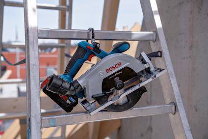 Cirkelsåg av märket Bosch ligger på en stege, med bakgrund av byggarbetsplats.