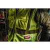 Person wearing a yellow and black high-visibility vest with "Milwaukee" logo, in a workshop setting.