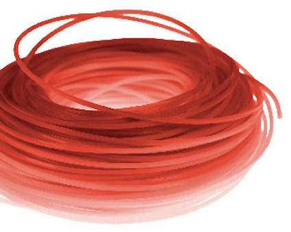 Röd rullad trimmertråd i plast, liggande i en hög.