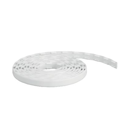 Vit plasttäcklist upprullad i en cirkel med perforerade spår längs hela längden.