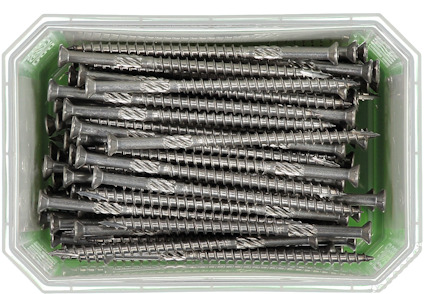 Silverfärgade skruvar i en transparent plastbehållare med grönt undertill.