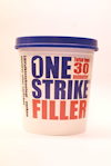 Spackelhink med blått lock, märkning "ONE STRIKE FILLER" i röd och blå text samt "Torkar inom 30 minuter" på framsidan.
