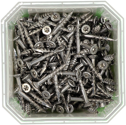 Silverfärgade skruvar med stjärnformade huvuden i en fyrkantig, transparent plastbehållare.