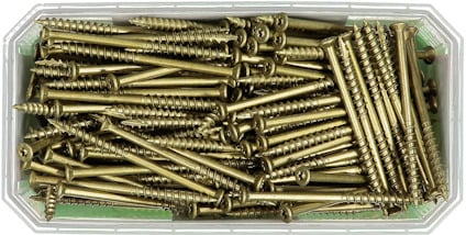 Fyrkantig transparent behållare fylld med metallskruvar, guld- eller mässingsfärgade.