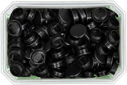 Svart plastlåda fylld med svarta gummiproppar eller pluggar.