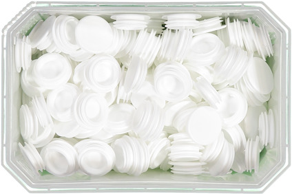 Vita plastlock i en genomskinlig rektangulär plastbehållare.