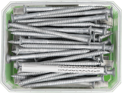 Metallskruvar och grå plastpluggar i en rektangulär plastbehållare.