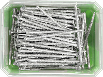 En plastlåda fylld med flera silverfärgade skruvar, organiserade parallellt.