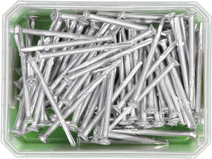 En genomskinlig låda fylld med silverfärgade skruvar på en grön bakgrund.