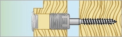 Träplanka med en monterad skruv som går genom en metallhylsa.
