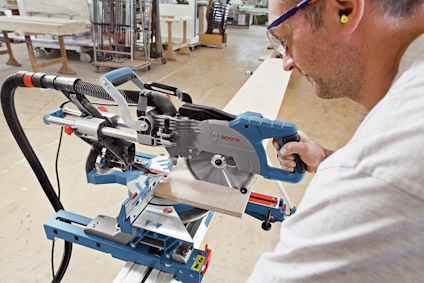 Person använder geringssåg inomhus, med säkerhetsglasögon och hörselskydd.