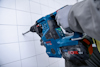 Blå borrmaskin med texten "Bosch ProCORE 18V" borrar i kakelvägg.