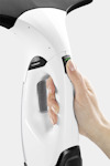 Vit och svart elektrisk handhållen enhet med en hand som trycker på en knapp.