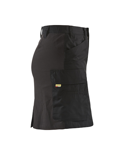 Svart arbetskjol med stora fickor på sidan och bälte upptill.