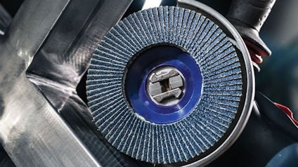 Sliprondell monterad på en vinkelslip, med blå och grå lameller i närbild på metallbakgrund.