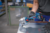 En person använder en sladdlös Bosch-metallsax på en metallplåt.