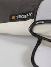 Handske med etiketten "TEGERA" synlig på kanten. Mörkgrå och vit färg med svart kantning.