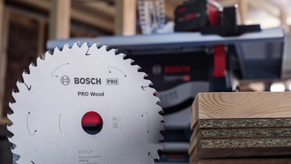 Cirkelsågklinga märkt "Bosch PRO Wood" bredvid staplade träskivor.