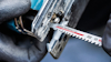 Jigsaw with Bosch "Expert Hardwood fast" blade, close-up of gloved hands holding tool.